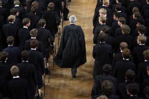 Eton College students stand as headmaster, Tony Little, enters the hall